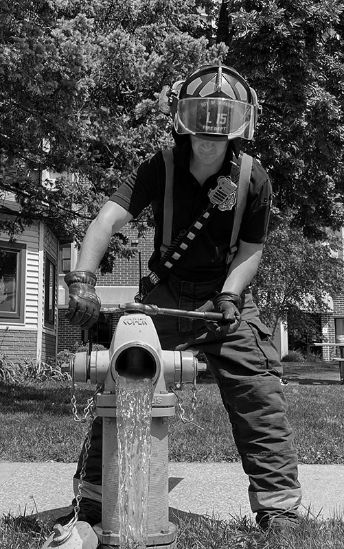 Photo of a firefighter opening a fire hydrant
