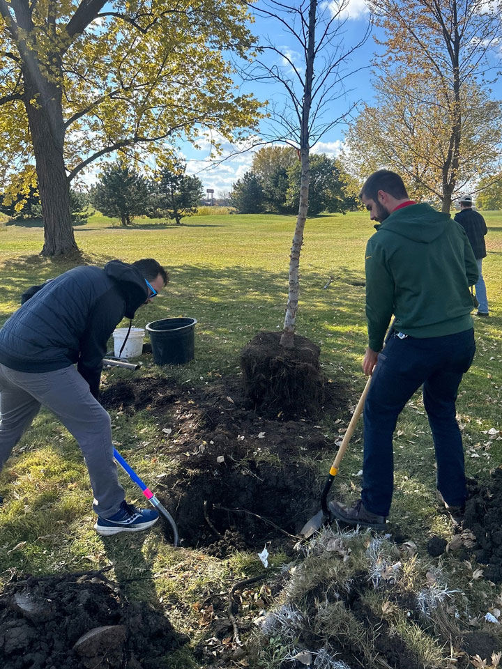2 gentleman volunteering for the Oshkosh Parks Department by helping to plant a tree in our park