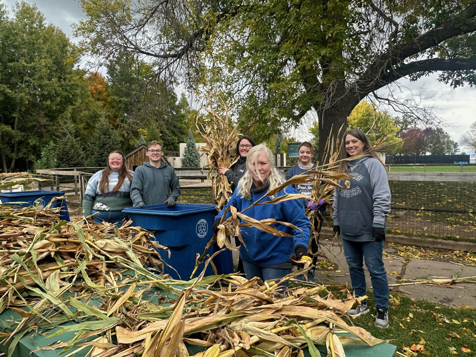 A group of volunteers helping out in the Menominee Park Zoo by putting up corn stalks around the zoo to get ready for the fall and our Zooloween Boo event